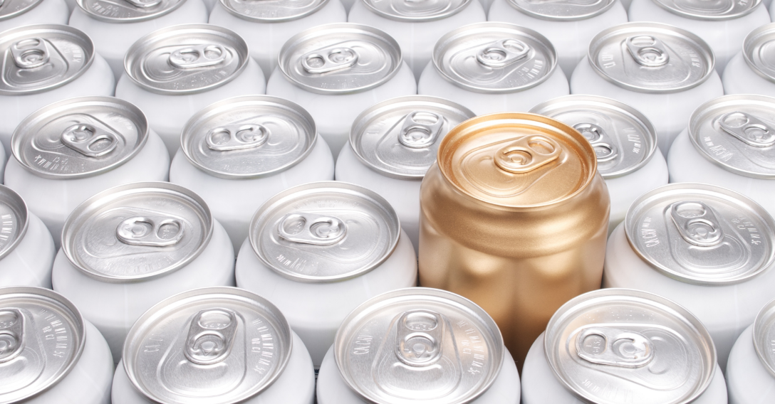 Silver pop cans together with one gold can risen above the others